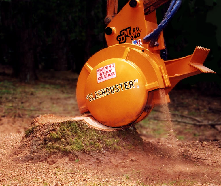 A stump grinder cutting into a tree stump with sawdust around the cut.